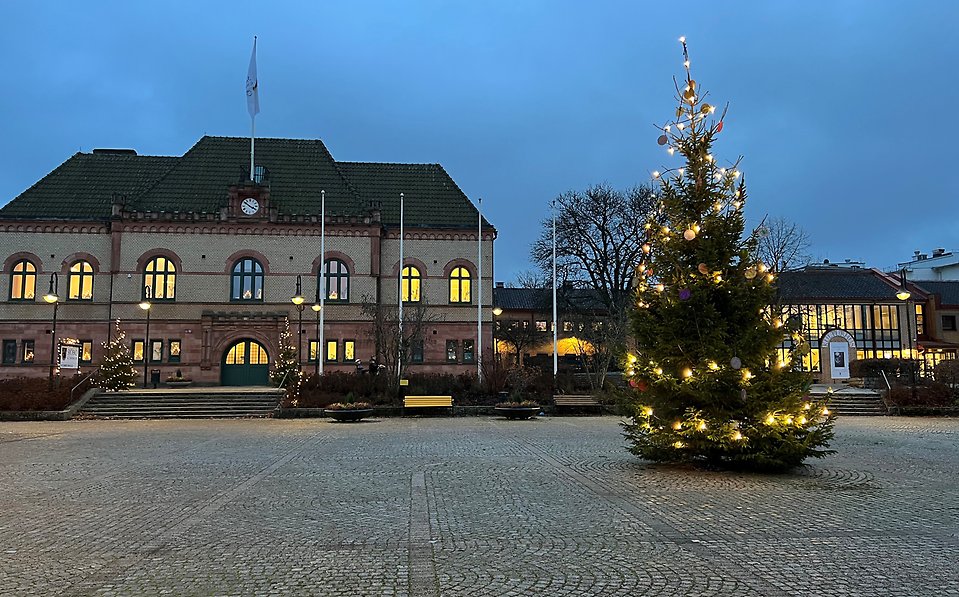 Koomunhuset Sjöbo i decembermörker med julgran och julljus