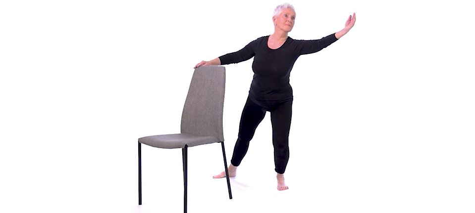 Kvinna tränar balans stående vid stol set 2 träningsprogram