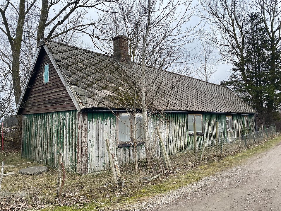 Fallfärdigt hur med flagad grön fasadpanel. 