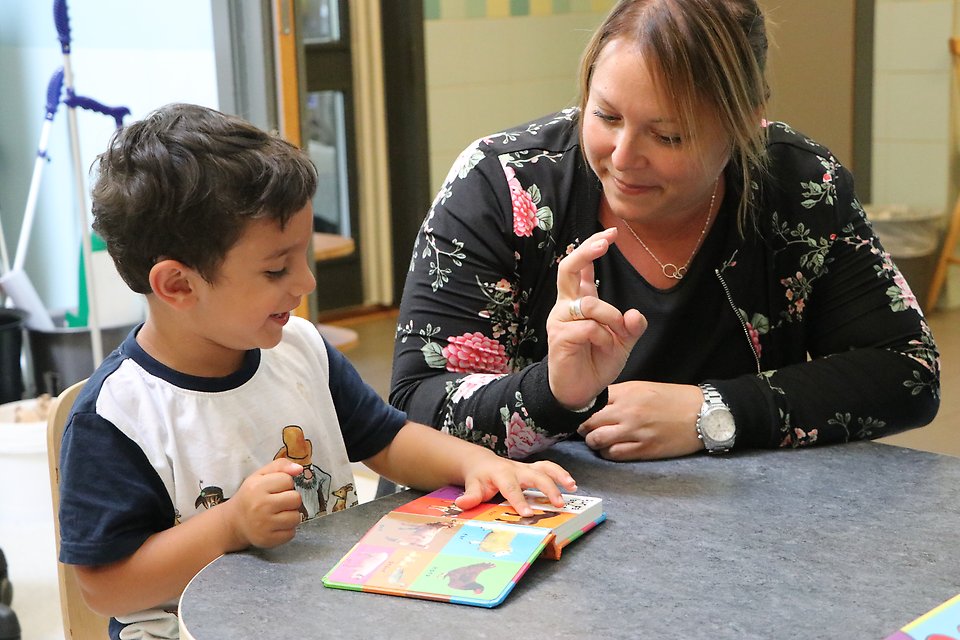 Barn och pedagog läser bok tillsammans, förskolan Sjöbo kommun